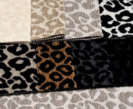 Tkaniny obiciowej WILD z motywem panterki w różnych wariantach kolorystycznych – beżowym, karmelowym, szarym i czarno-białym, o miękkiej pluszowej strukturze.jpg